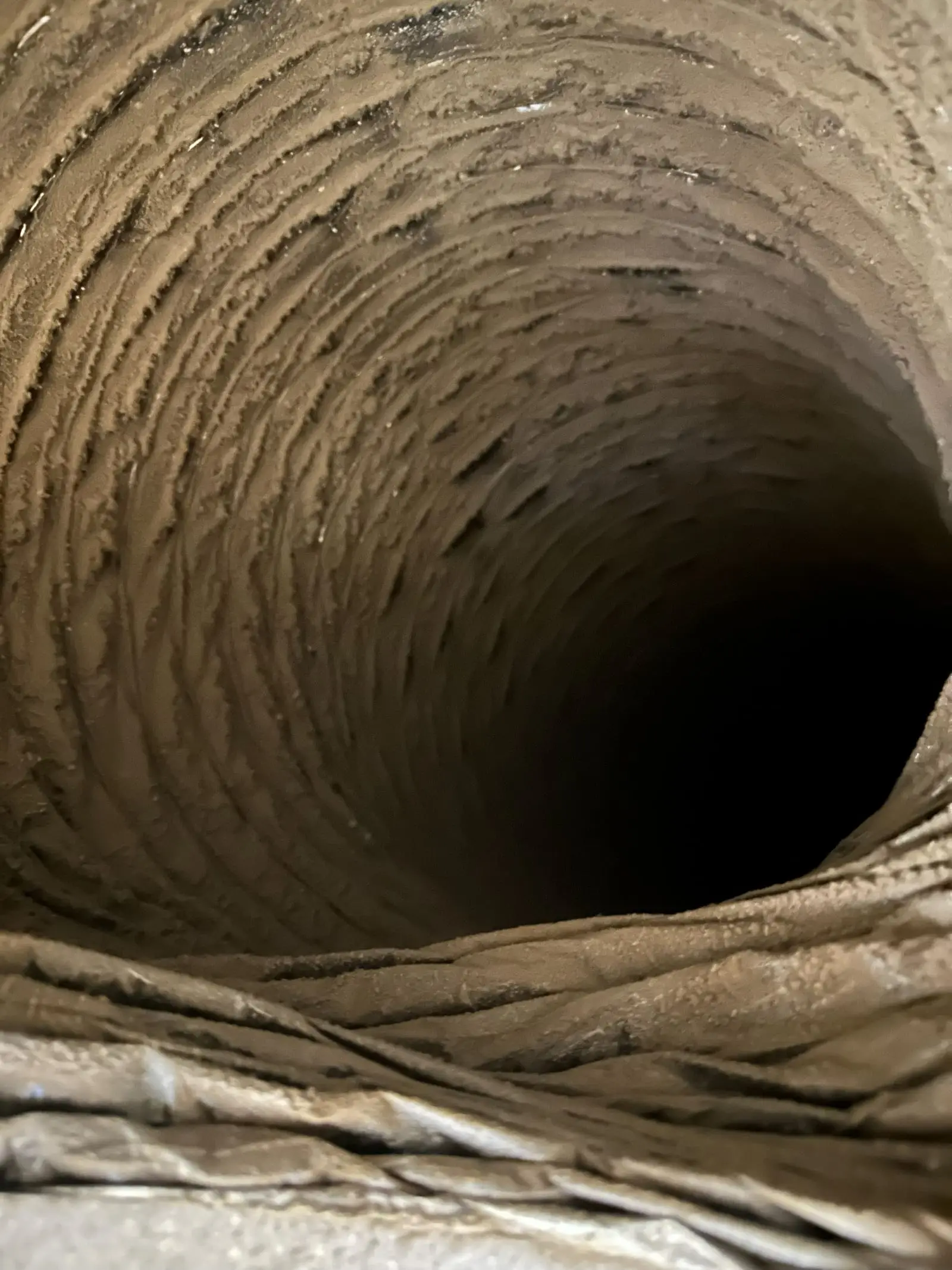 View down a flexible HVAC duct after cleaning, with the ribbing clear of dust