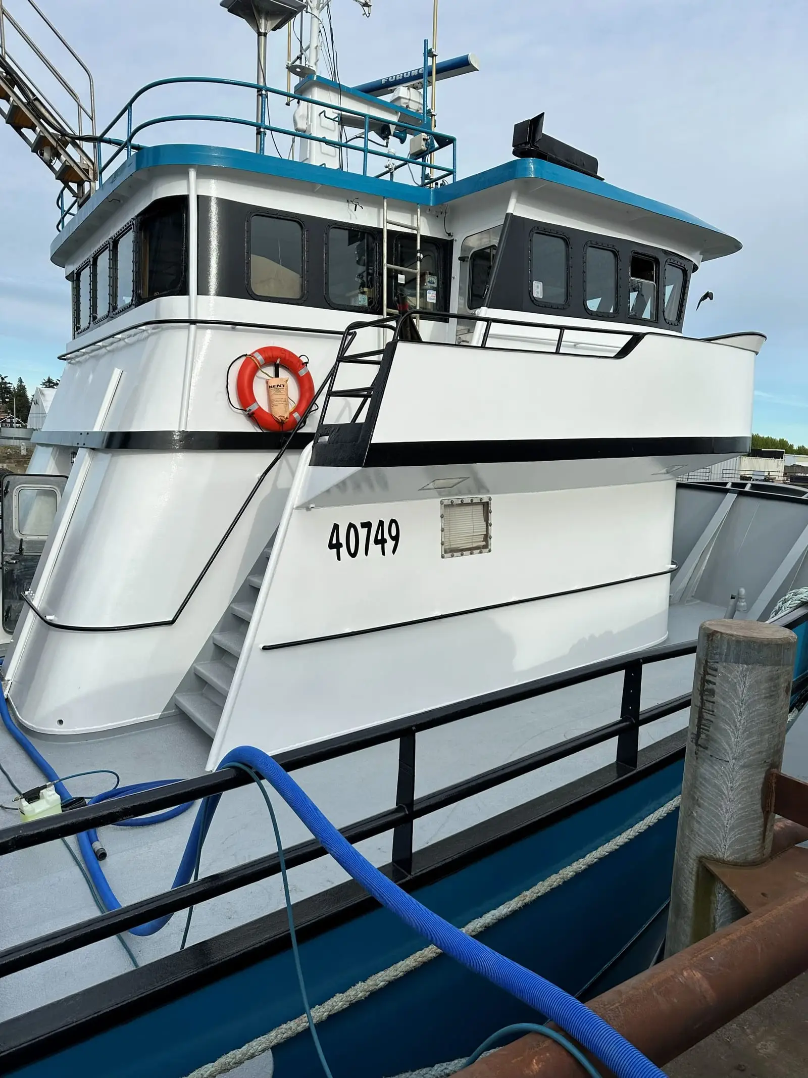 A commercial fishing vessel at dock in Anacortes with cleaning hoses run aboard from the van